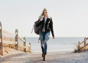 Stylish woman in leather jacket walking by the ocean in Ocean City, NJ.