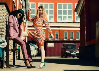 Stylish women posing in an urban alley showcasing contemporary fashion trends.
