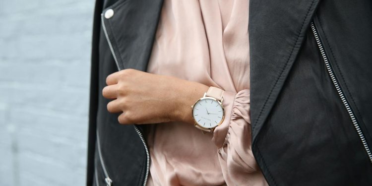 Stylish woman in a leather jacket showcasing an elegant wristwatch, perfect for fashion-forward individuals.