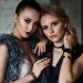 Elegant portrait of two fashionable women showcasing modern style and beauty against a textured backdrop.