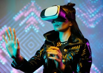 Woman using VR headset with interactive neon lights indoors, embracing digital innovation.