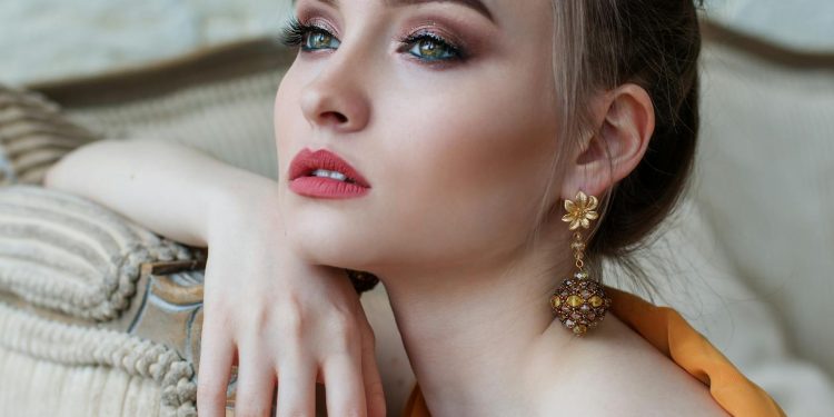 Stunning close-up portrait of a woman with elegant makeup and jewelry, epitomizing modern fashion and beauty.